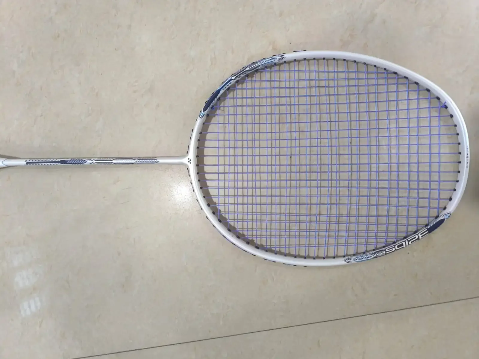 Close view of Astrox Attack 9 badminton racket head with blue string bed